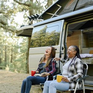 Multiracial Traveling Women Laughing Near Camper