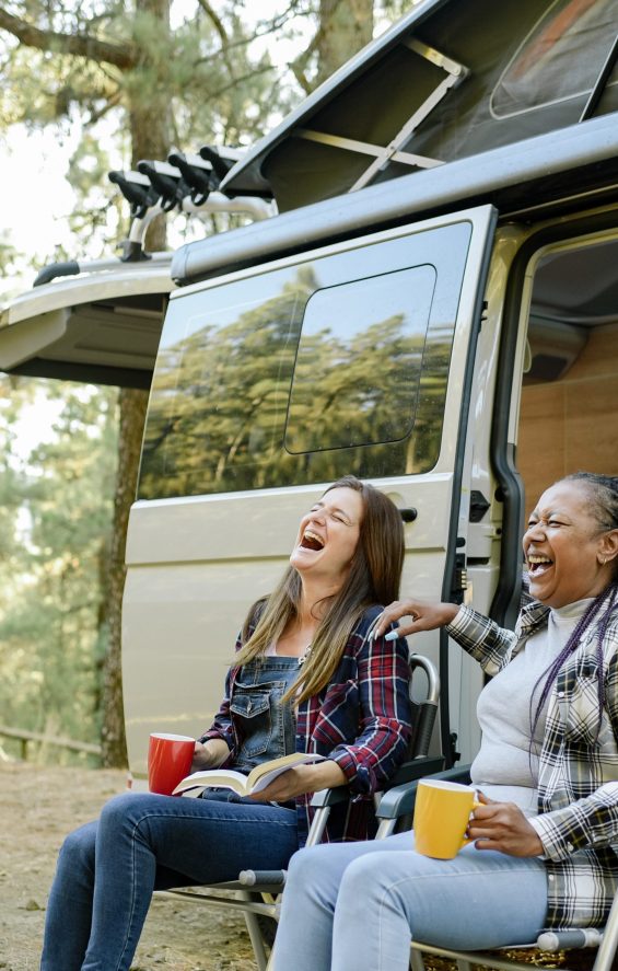 Multiracial Traveling Women Laughing Near Camper